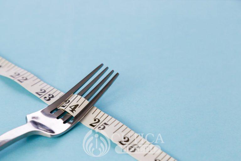 metal-dining-fork-and-inch-tape-on-color-background-symbolizes-weight-loss-free-space-for-text-no_t20_1QOARY-768x512