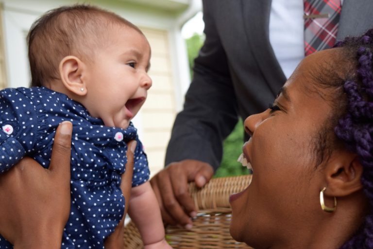 black-woman-lifting-up-and-smiling-and-laughing-with-baby-girl_t20_rK6wKw-768x512