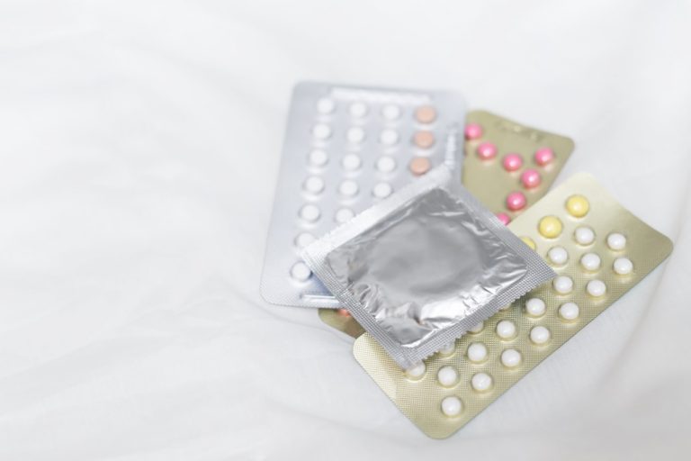 condoms-and-birth-control-pills-on-the-bed_t20_QKE9LA-768x512