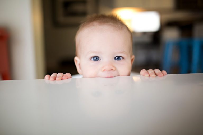 little-baby-boy-chewing-on-a-white-table_t20_8l2mV6-1-768x512