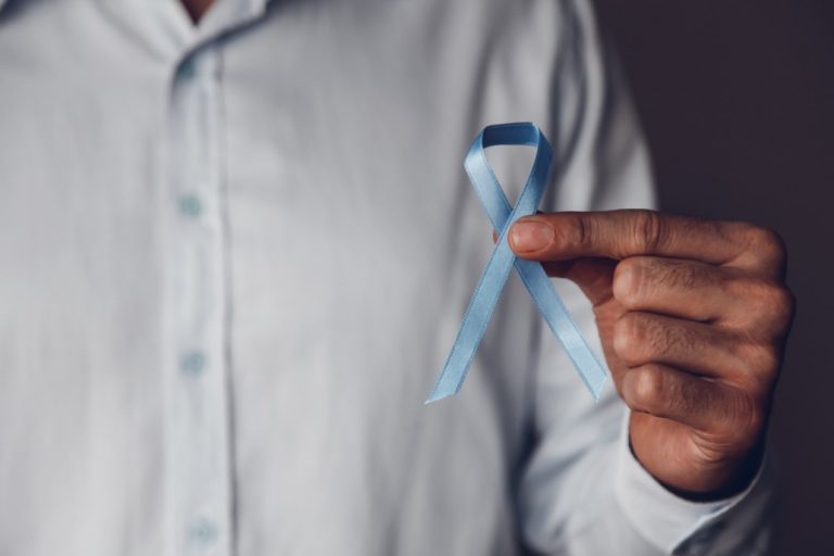 man-doctors-hands-holding-a-blue-ribbon-in-front-of-him-prostate-cancer-awareness-month-mens-cancer_t20_WxrEmz-768x512