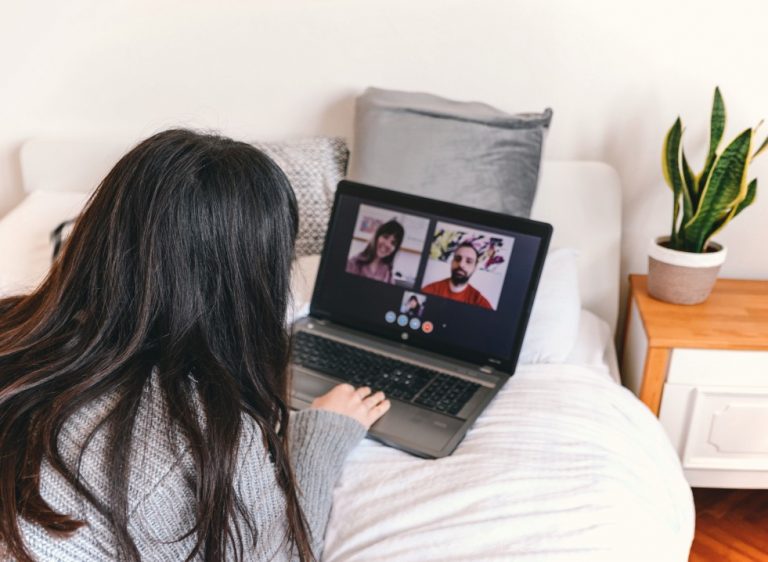 young-woman-video-chatting-on-laptop-at-home-laying-on-bed-virtual-meeting-webinar-app-application_t20_xXzXNg-768x562